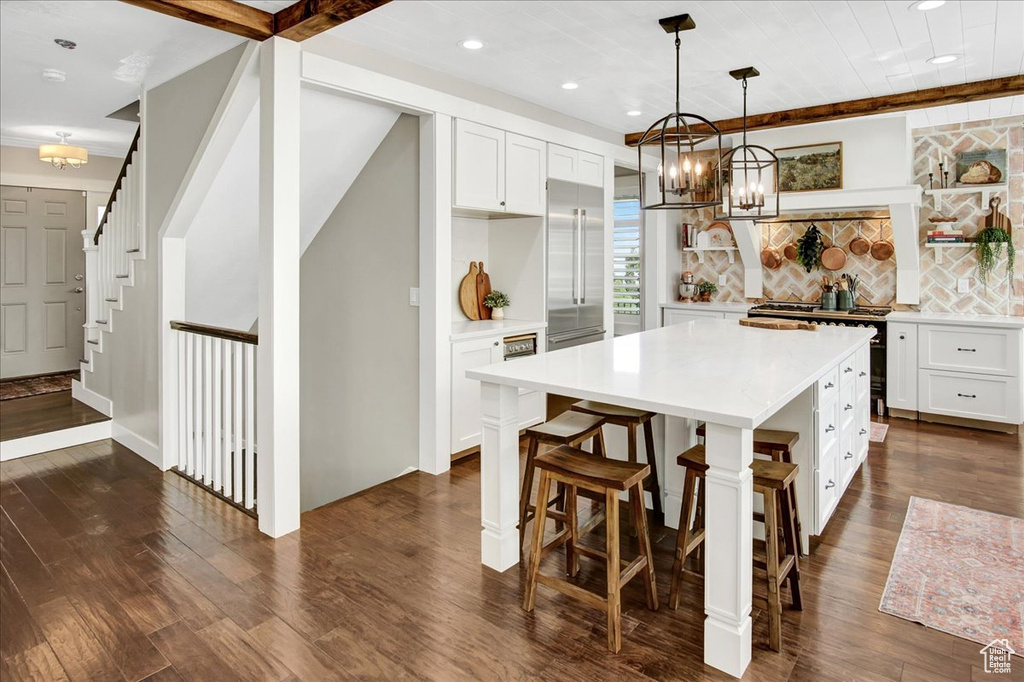 Kitchen with a chandelier, premium appliances, light countertops, recessed lighting, and dark wood-style flooring