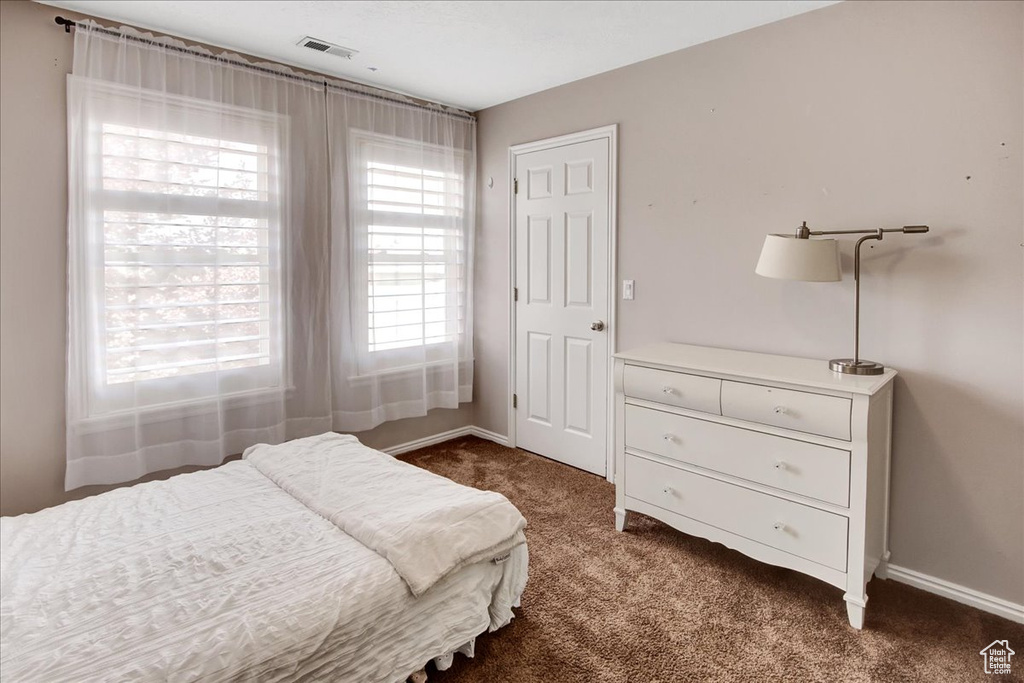 Bedroom featuring dark colored carpet and baseboards