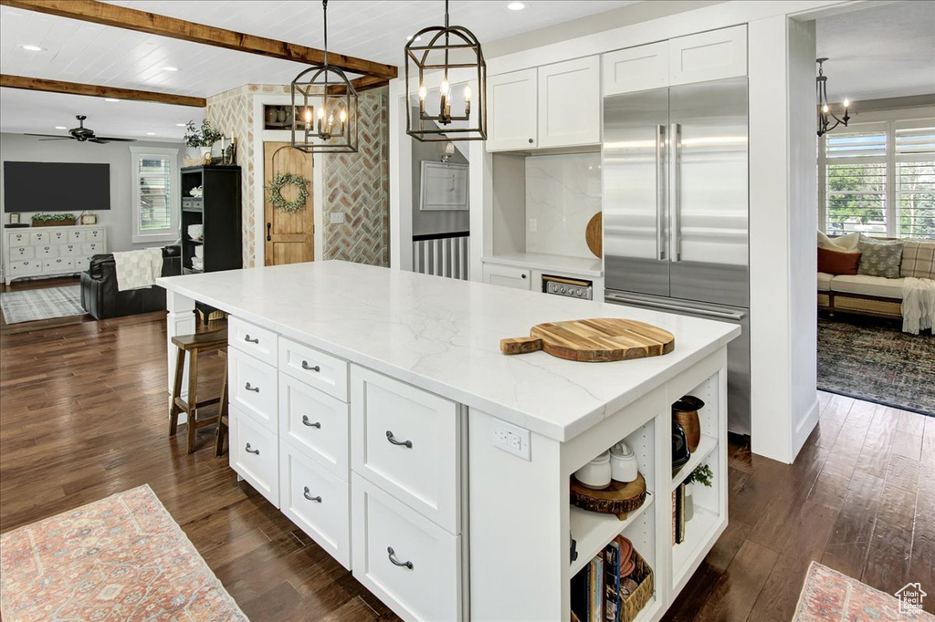 Kitchen with built in refrigerator, a chandelier, white cabinetry, open shelves, and recessed lighting