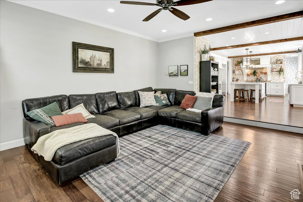 Living room featuring ceiling fan, wood-type flooring, recessed lighting, beam ceiling, and crown molding