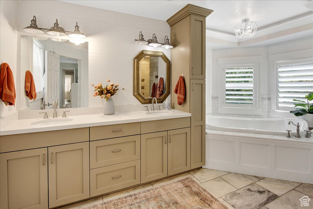 Full bathroom with double vanity, a bath, a chandelier, and marble finish floors