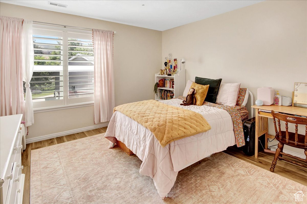 Bedroom with light wood-style floors and baseboards