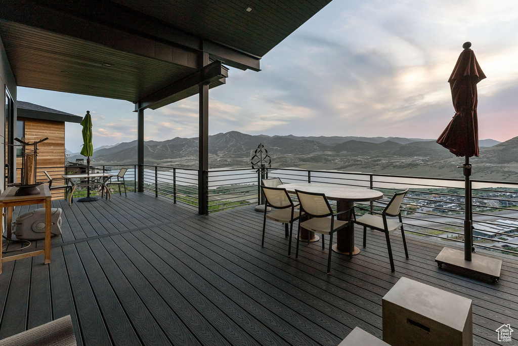 Wooden deck with outdoor dining space and a mountain view