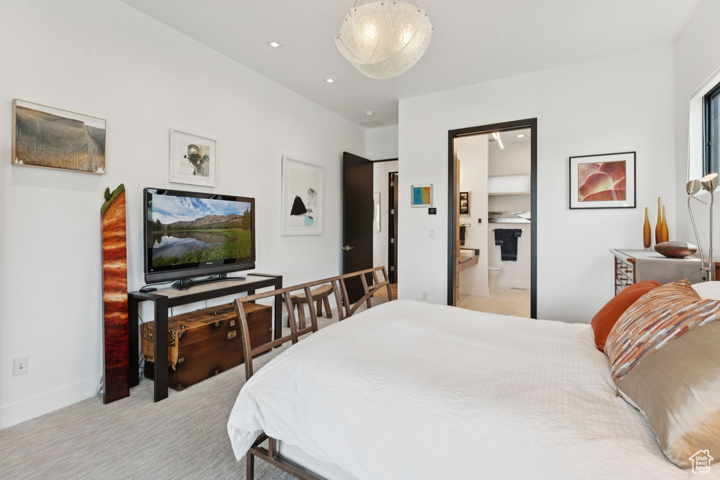 Bedroom featuring light carpet and connected bathroom