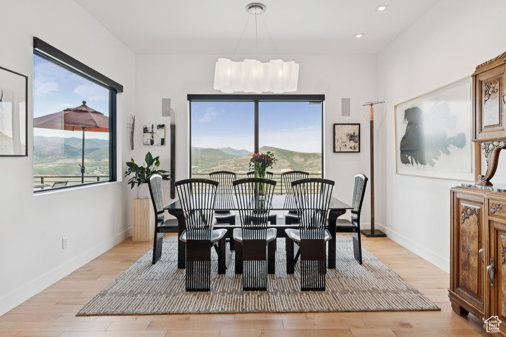 Dining space with light wood-style flooring, recessed lighting, and a chandelier