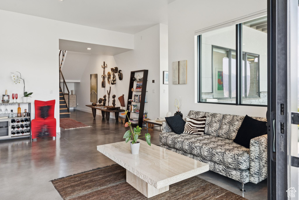 Living area featuring stairs, concrete flooring, and recessed lighting