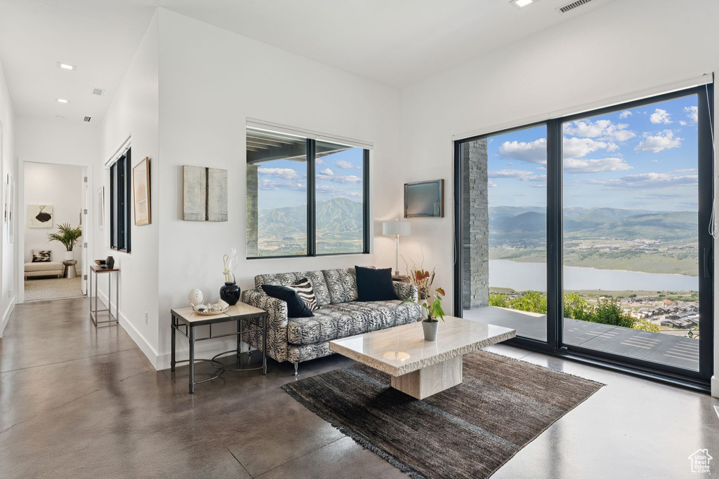 Living area featuring finished concrete floors and a water and mountain view