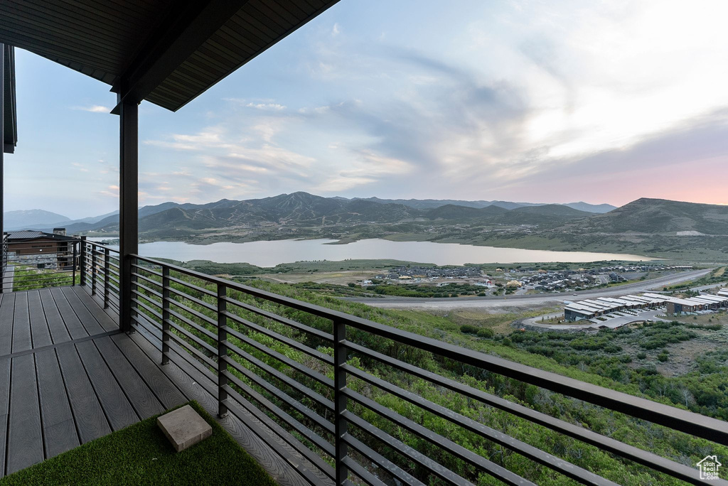 Balcony featuring a water and mountain view