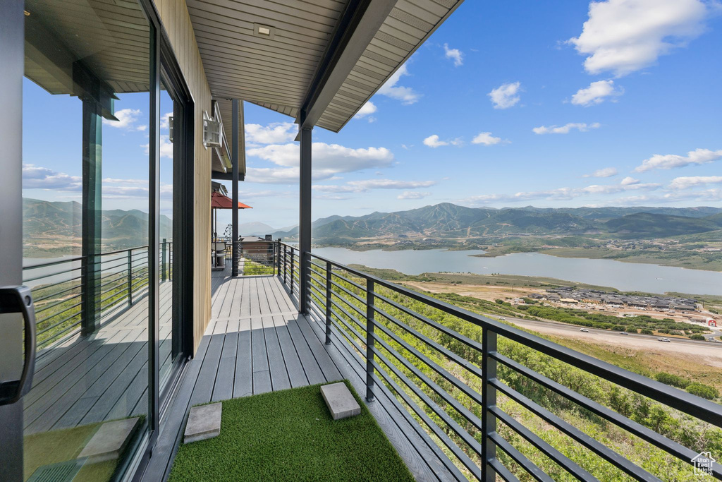 Balcony featuring a water and mountain view