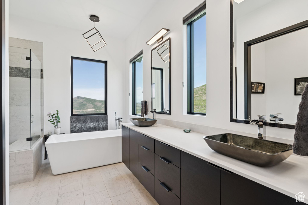 Full bath with a freestanding tub, double vanity, and a shower stall