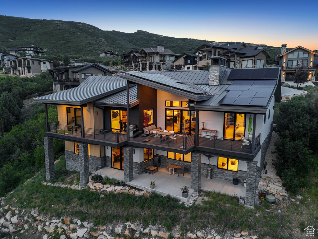 Rear view of house featuring a standing seam roof, a metal roof, and a patio area