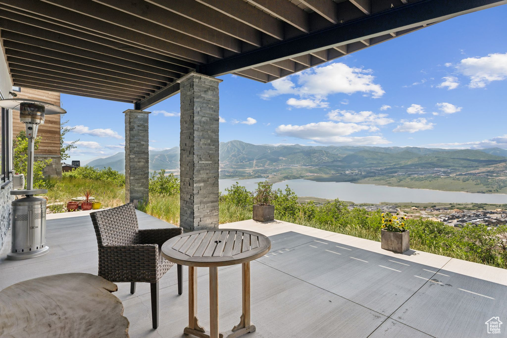 View of patio / terrace featuring a water and mountain view