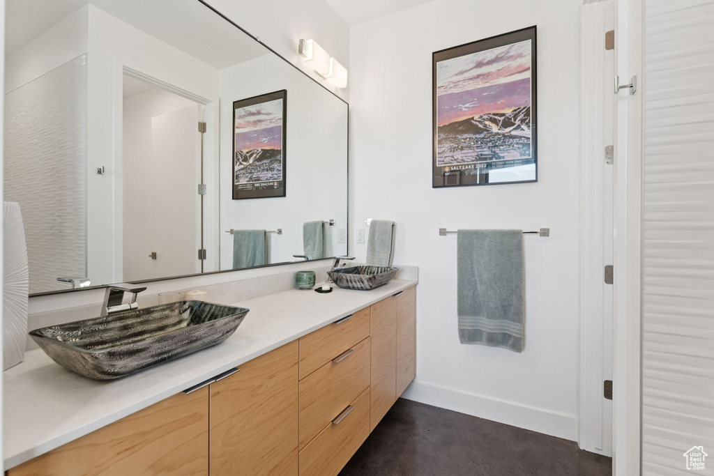 Bathroom with double vanity and baseboards