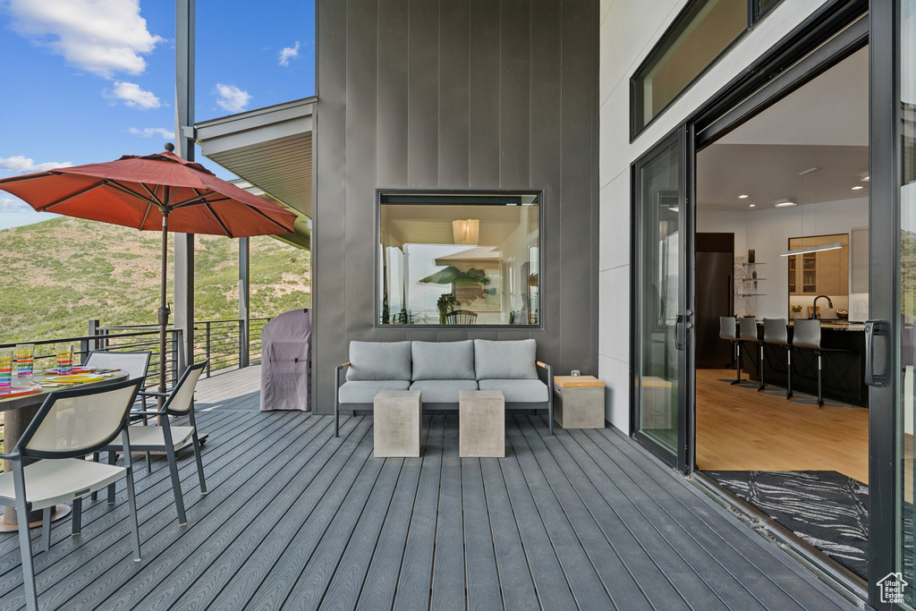 Wooden terrace featuring an outdoor hangout area and a sink