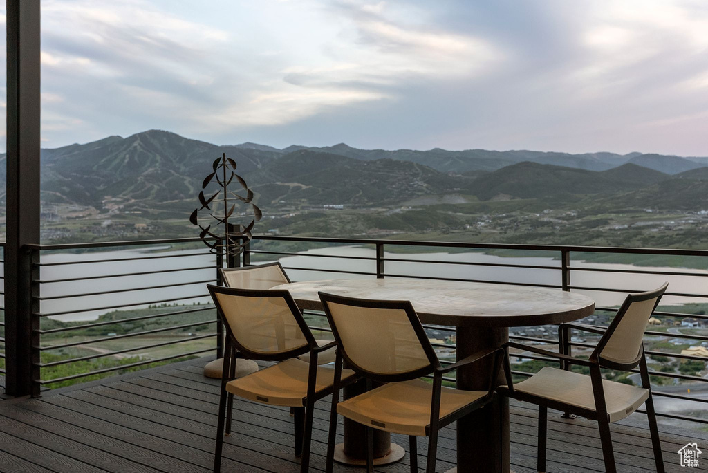 Wooden deck featuring outdoor dining area and a water and mountain view