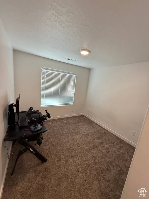 Carpeted empty room featuring baseboards