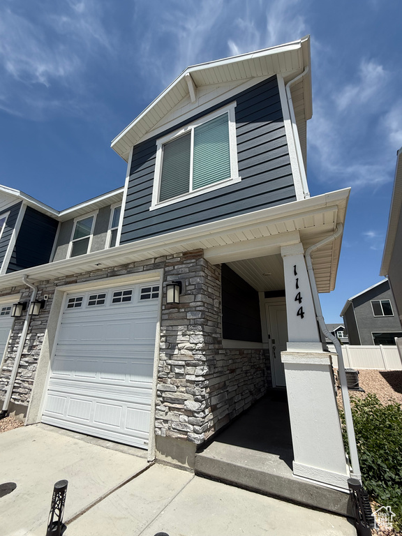 View of front of property featuring stone siding and concrete driveway