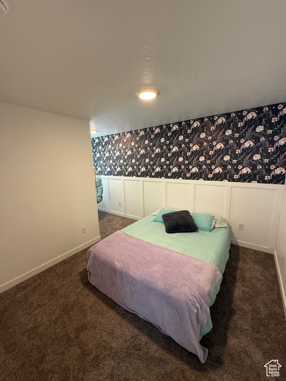 Bedroom featuring wallpapered walls and carpet floors
