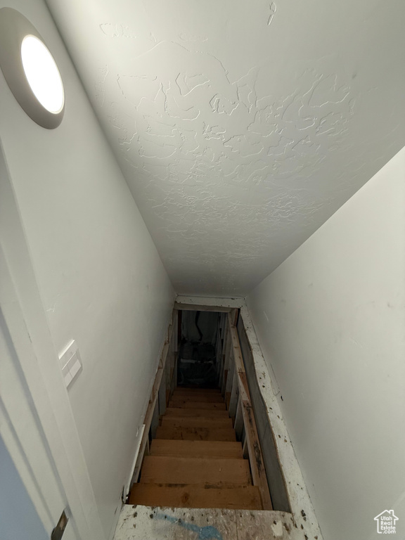 Stairs featuring a textured ceiling