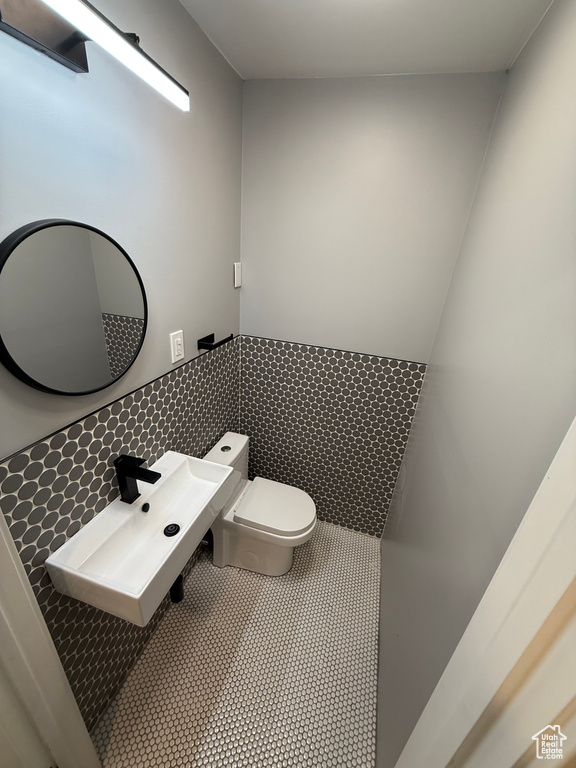 Bathroom featuring tile walls, a wainscoted wall, and tile patterned floors