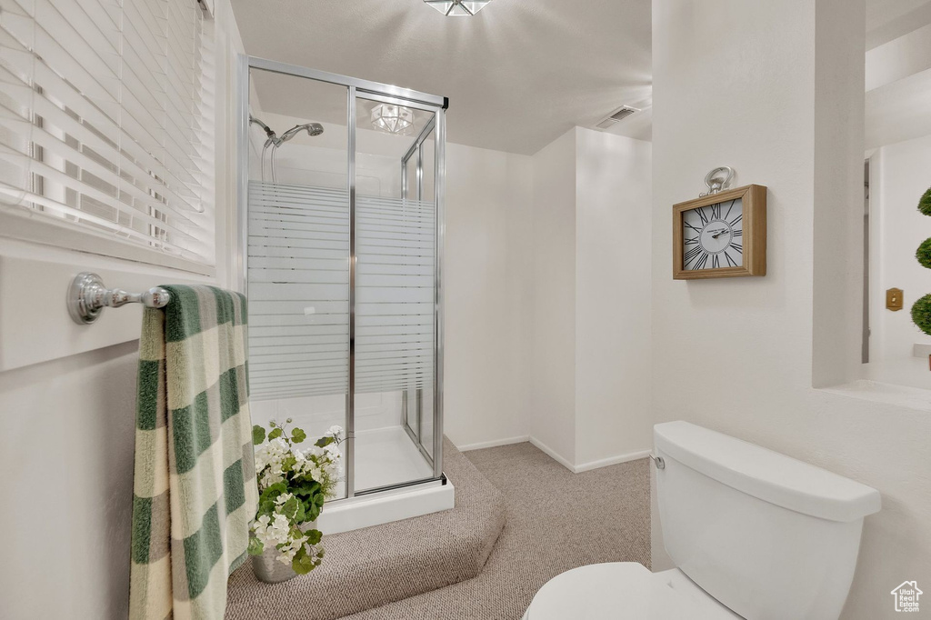 Full bath featuring a shower stall and toilet