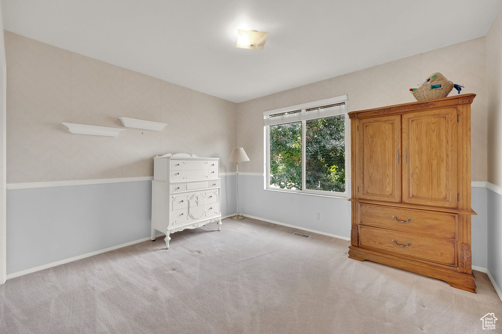 Bedroom featuring baseboards and light carpet