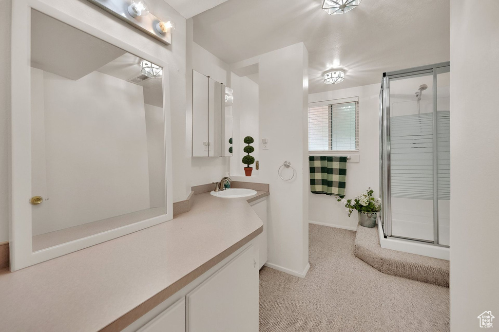 Full bath featuring vanity and a shower with shower door