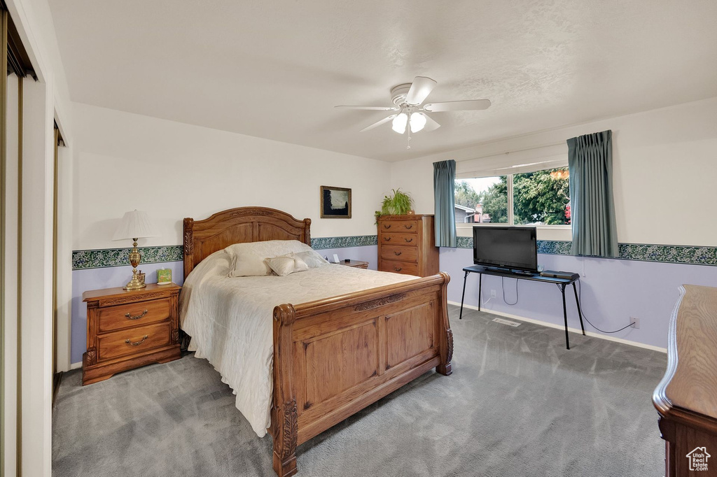 Carpeted bedroom featuring baseboards and a ceiling fan