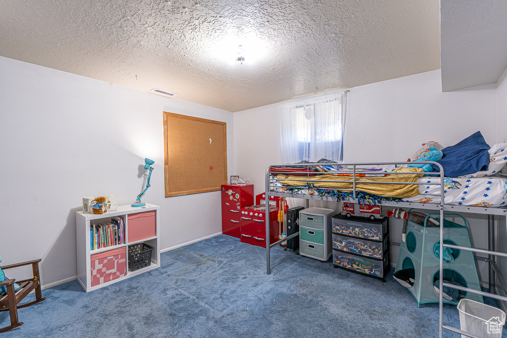 Carpeted bedroom featuring a textured ceiling