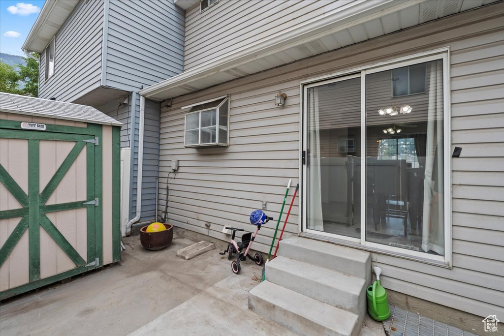View of patio featuring entry steps and a shed