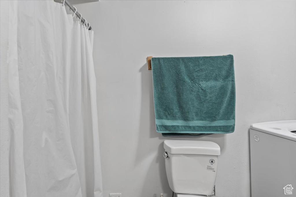 Bathroom with washer / dryer, vanity, and curtained shower