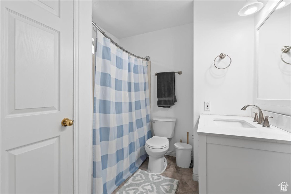 Bathroom featuring vanity, curtained shower, and tile patterned flooring