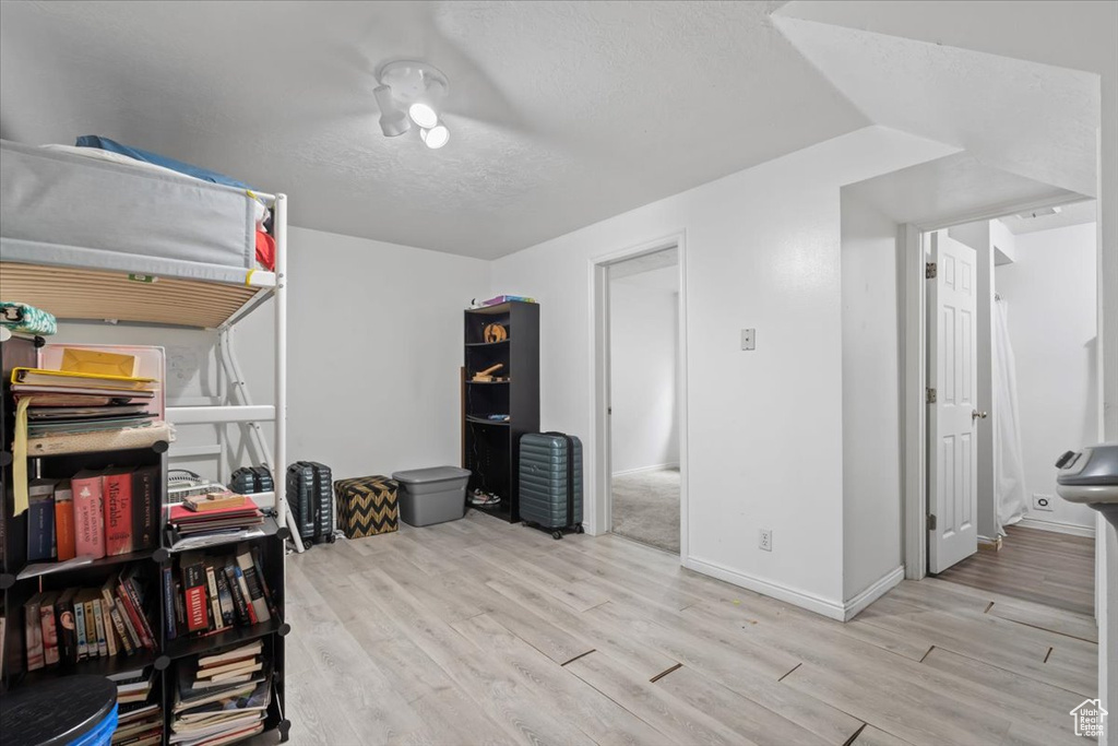 Bedroom with light wood finished floors and a textured ceiling
