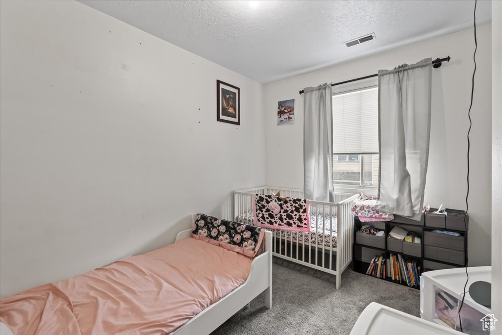 Bedroom featuring carpet floors and a textured ceiling
