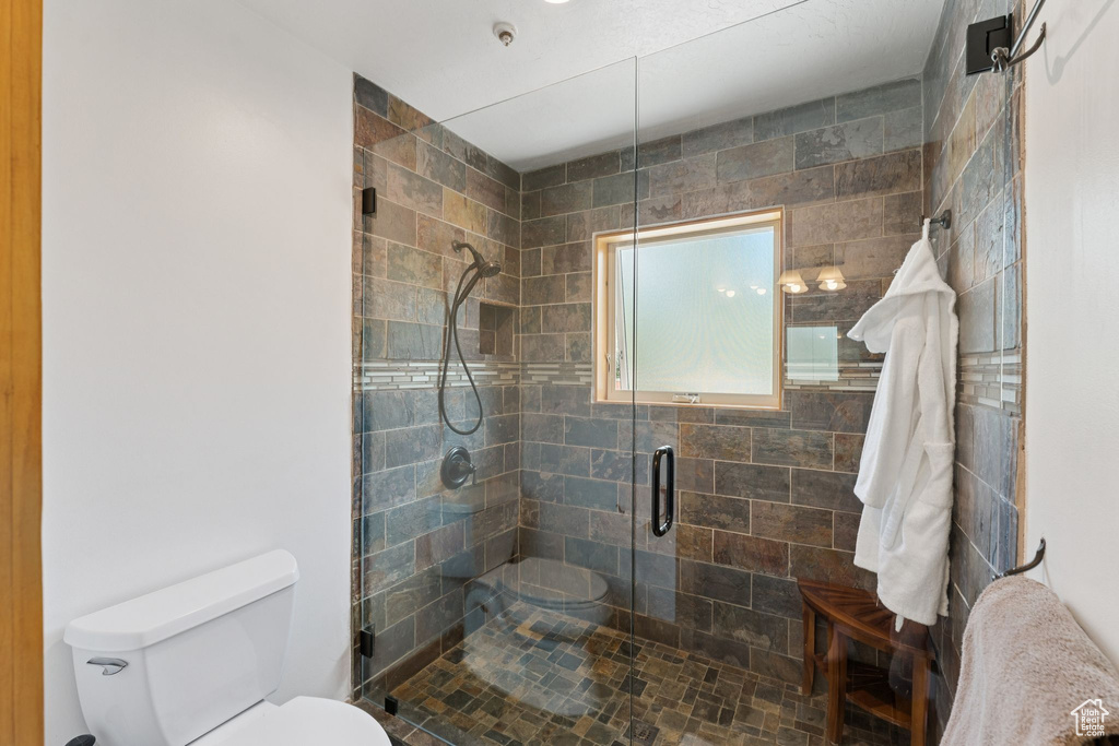 Full bathroom with toilet and a shower stall