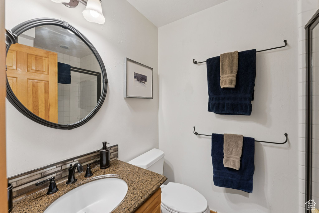 Full bath featuring tiled shower and vanity