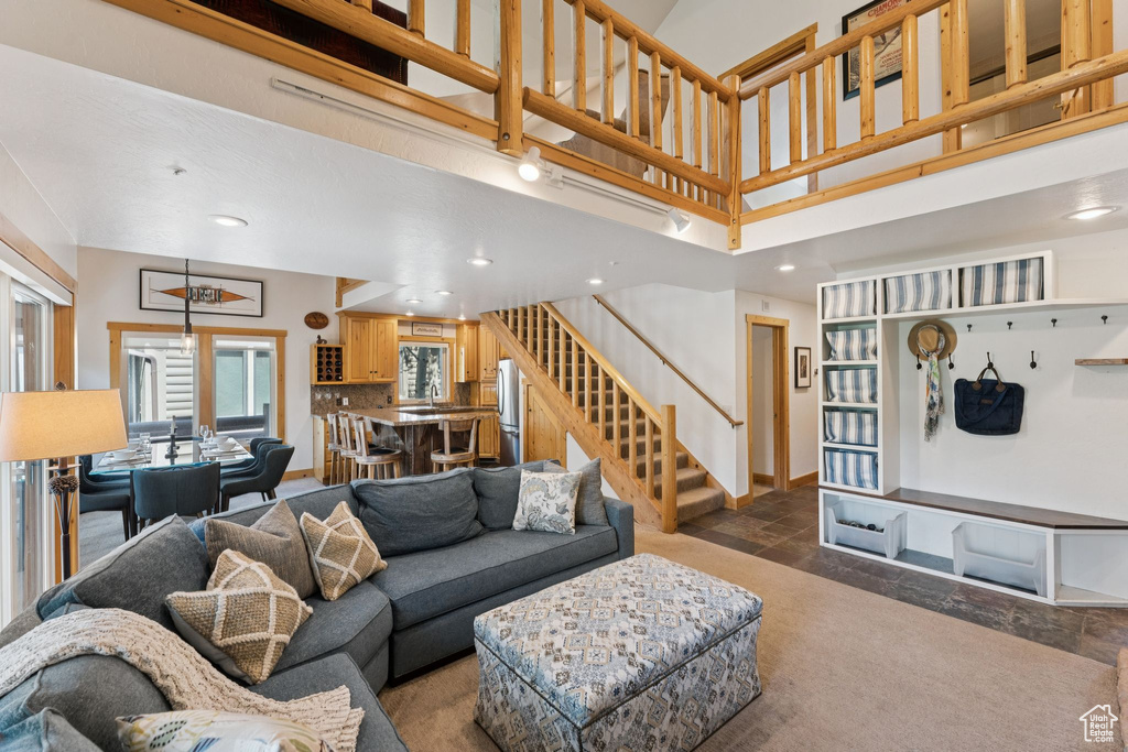 Living room with stairway, recessed lighting, and stone finish flooring