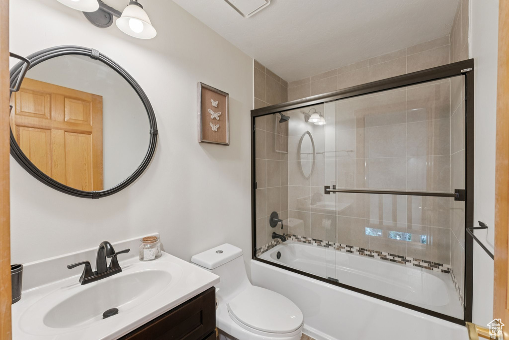 Full bath with combined bath / shower with glass door and vanity