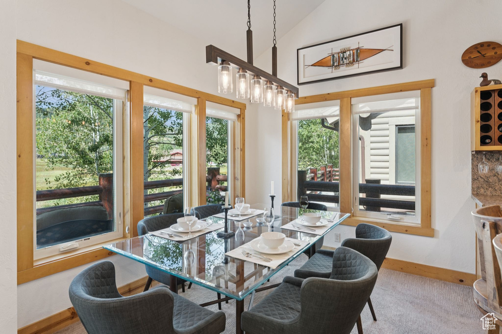 Dining area with vaulted ceiling and carpet flooring