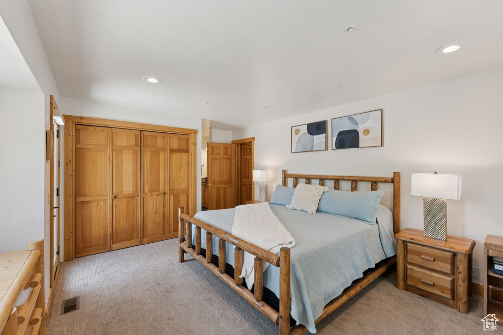 Bedroom with light colored carpet and recessed lighting