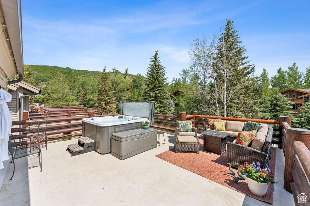 View of patio / terrace featuring an outdoor living space with a fire pit and a wooded view