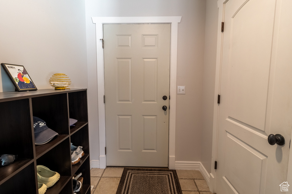 Doorway to outside featuring baseboards and light tile patterned flooring