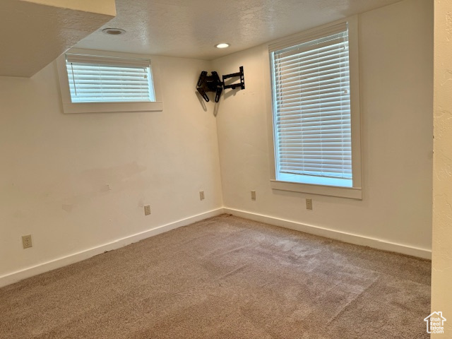 Spare room featuring carpet and a textured ceiling