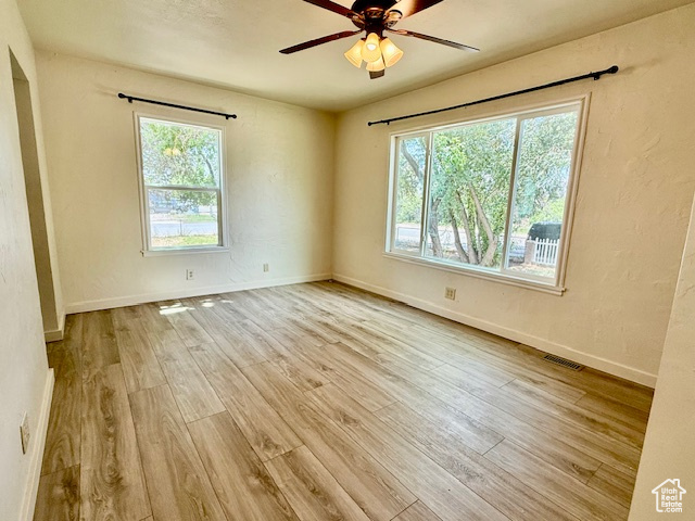 Spare room with wood finished floors and a ceiling fan