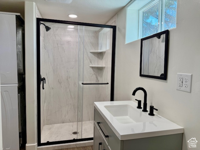 Full bath featuring vanity and a marble finish shower