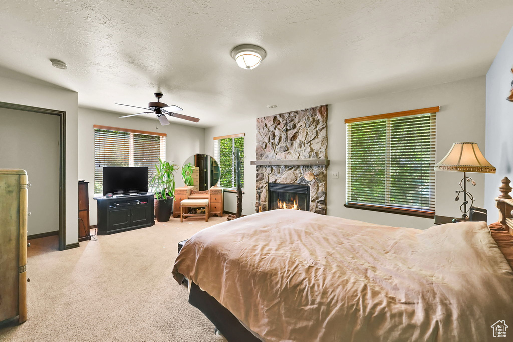 Bedroom with carpet, a fireplace, and a textured ceiling