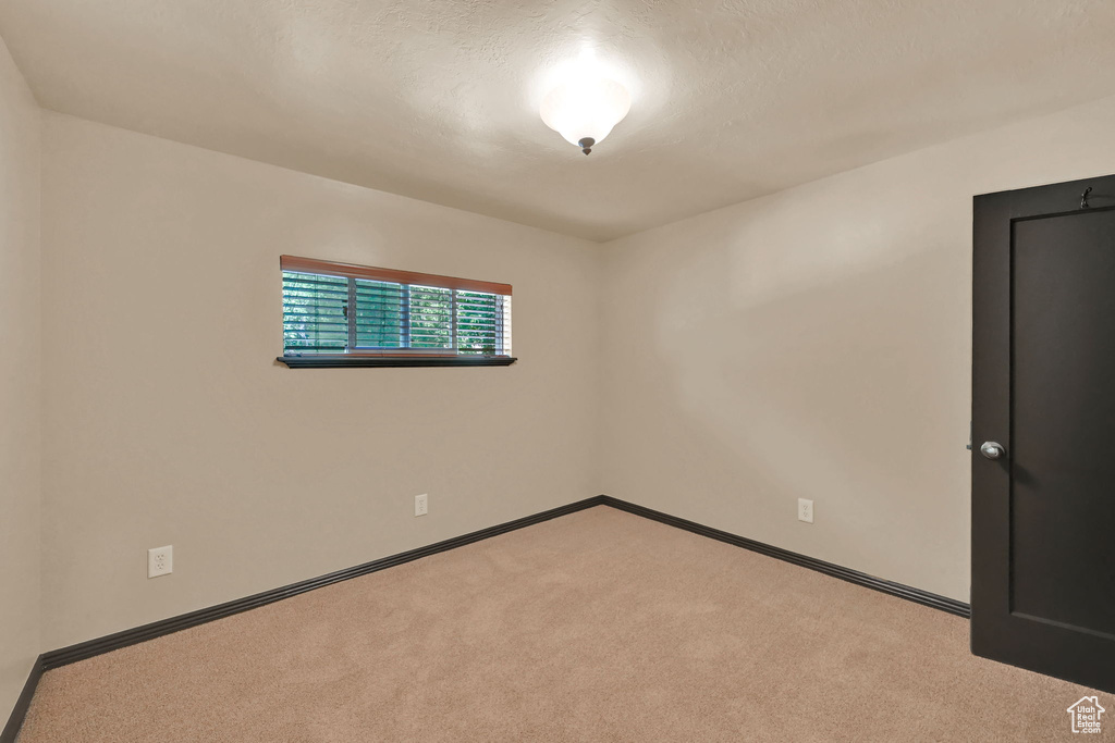 Carpeted spare room with baseboards