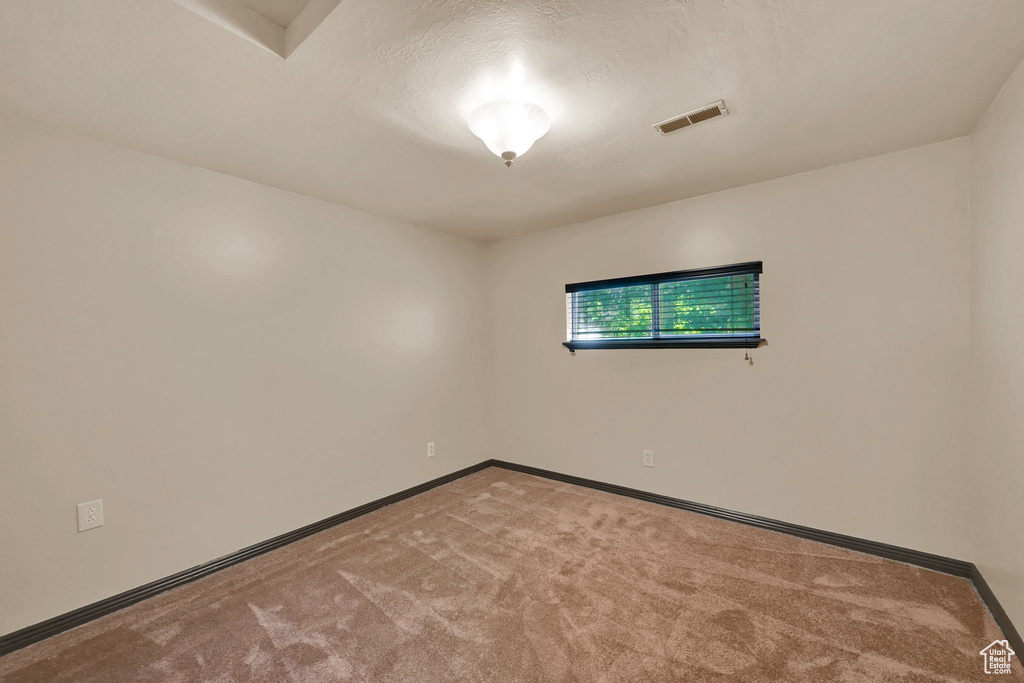 Carpeted empty room featuring baseboards