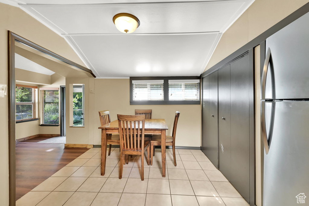Dining space featuring vaulted ceiling, plenty of natural light, and light tile patterned flooring