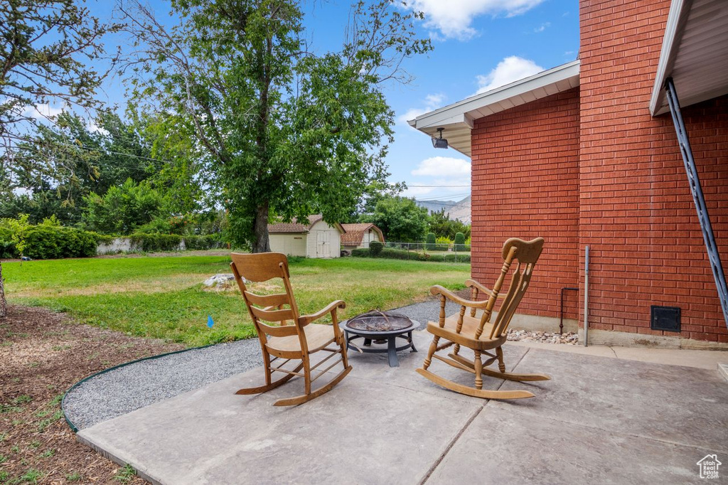 View of patio / terrace with a fire pit and a storage unit